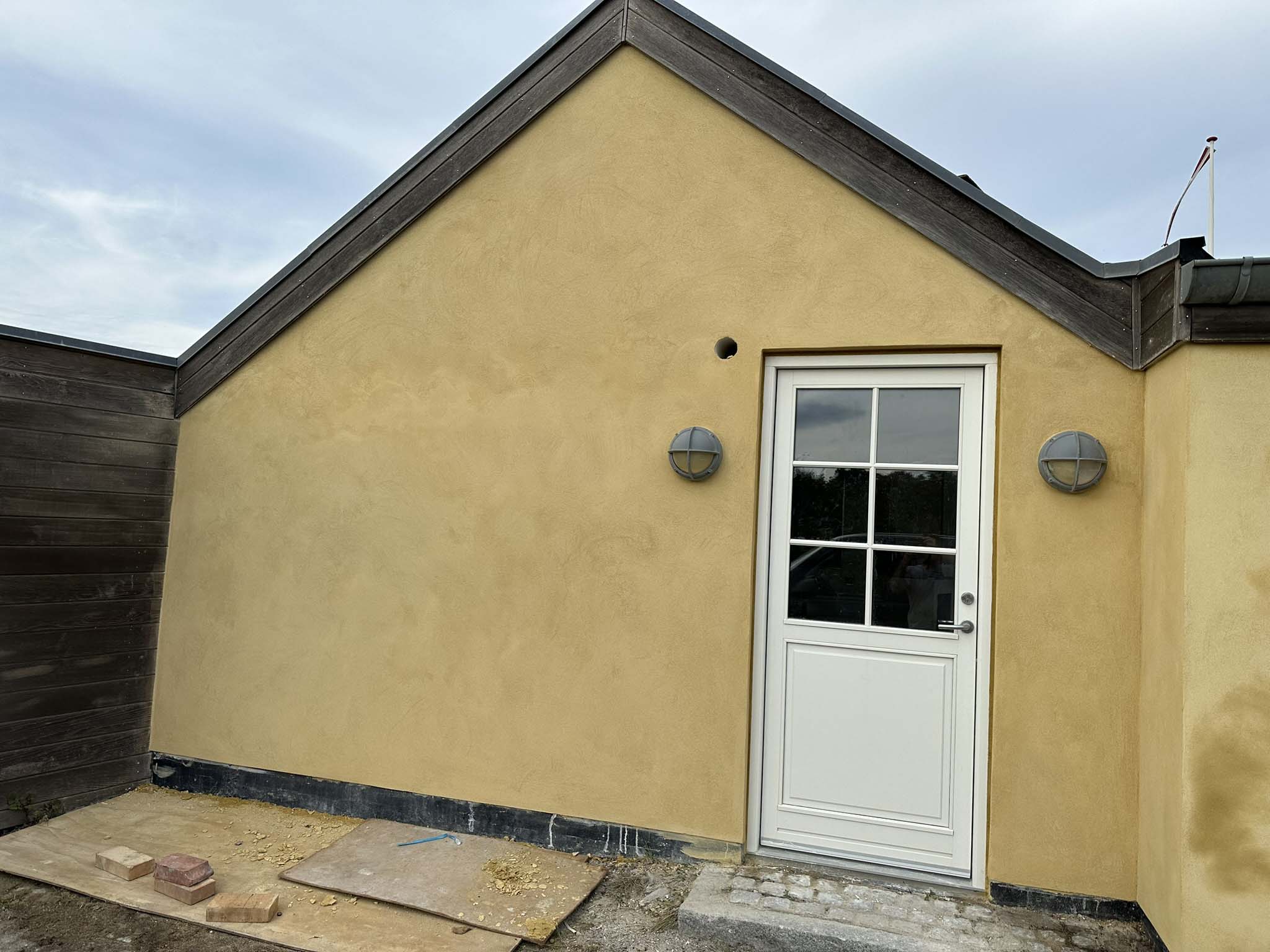 Samme gavl efter pudsning i gul farve med ny dør