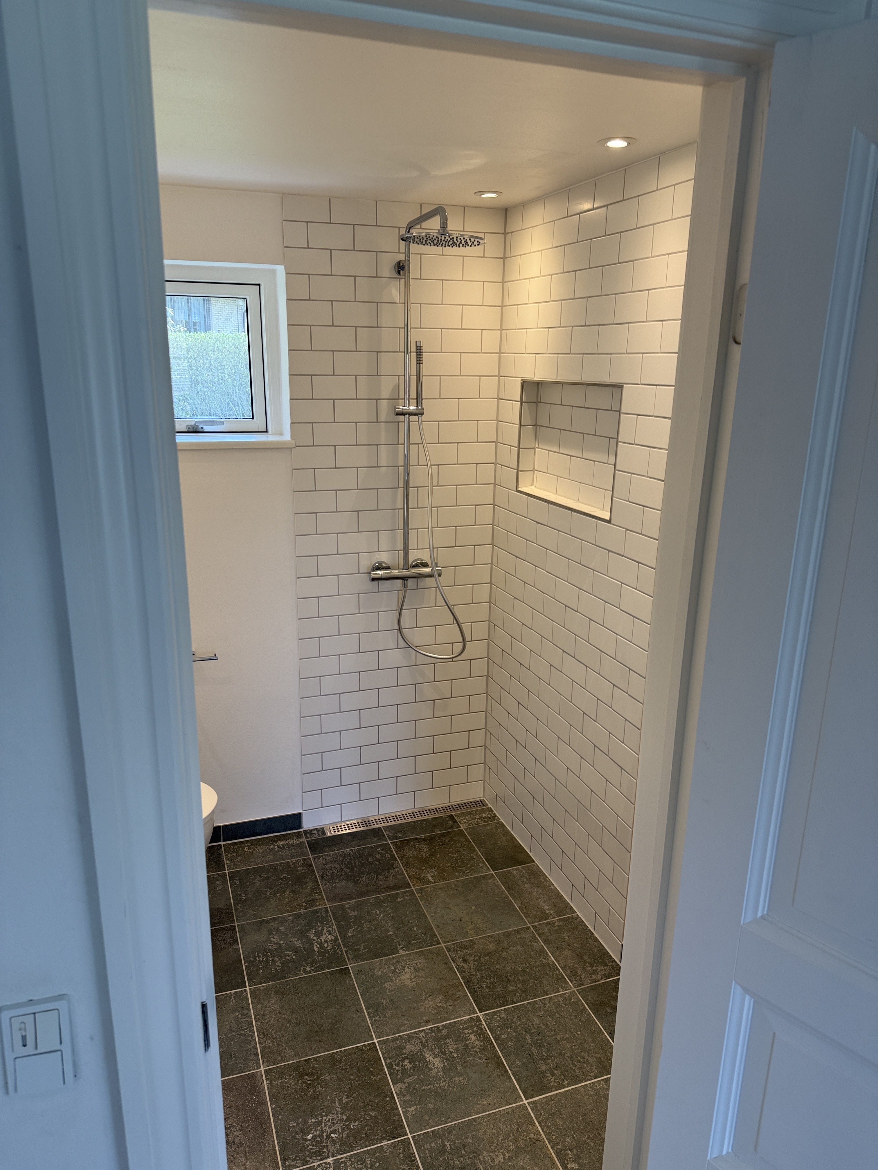 Bruseniche med hvide teglformatfliser og indbygget niche