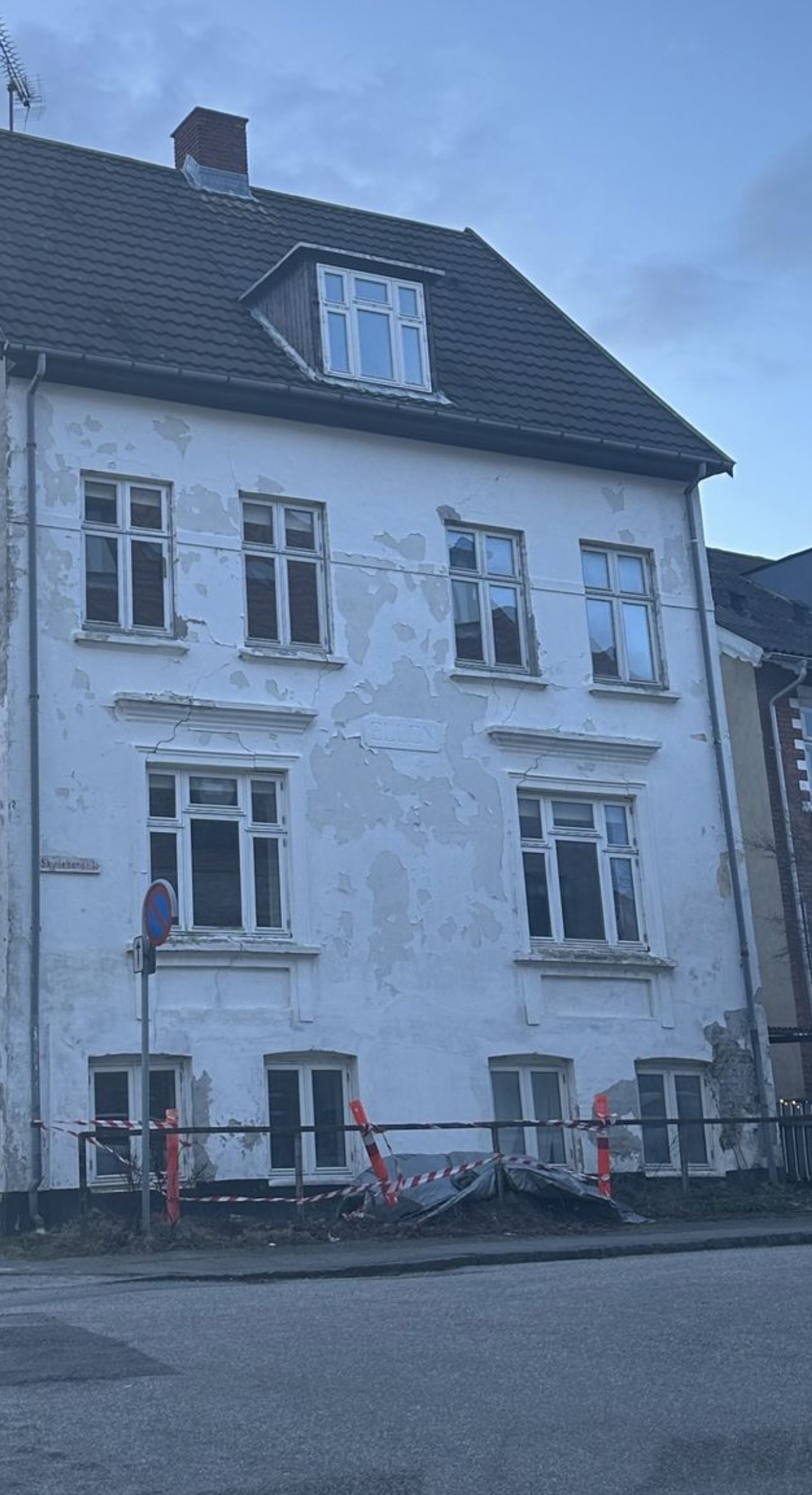 Ældre byejendom med afskallet facadepuds før renovering