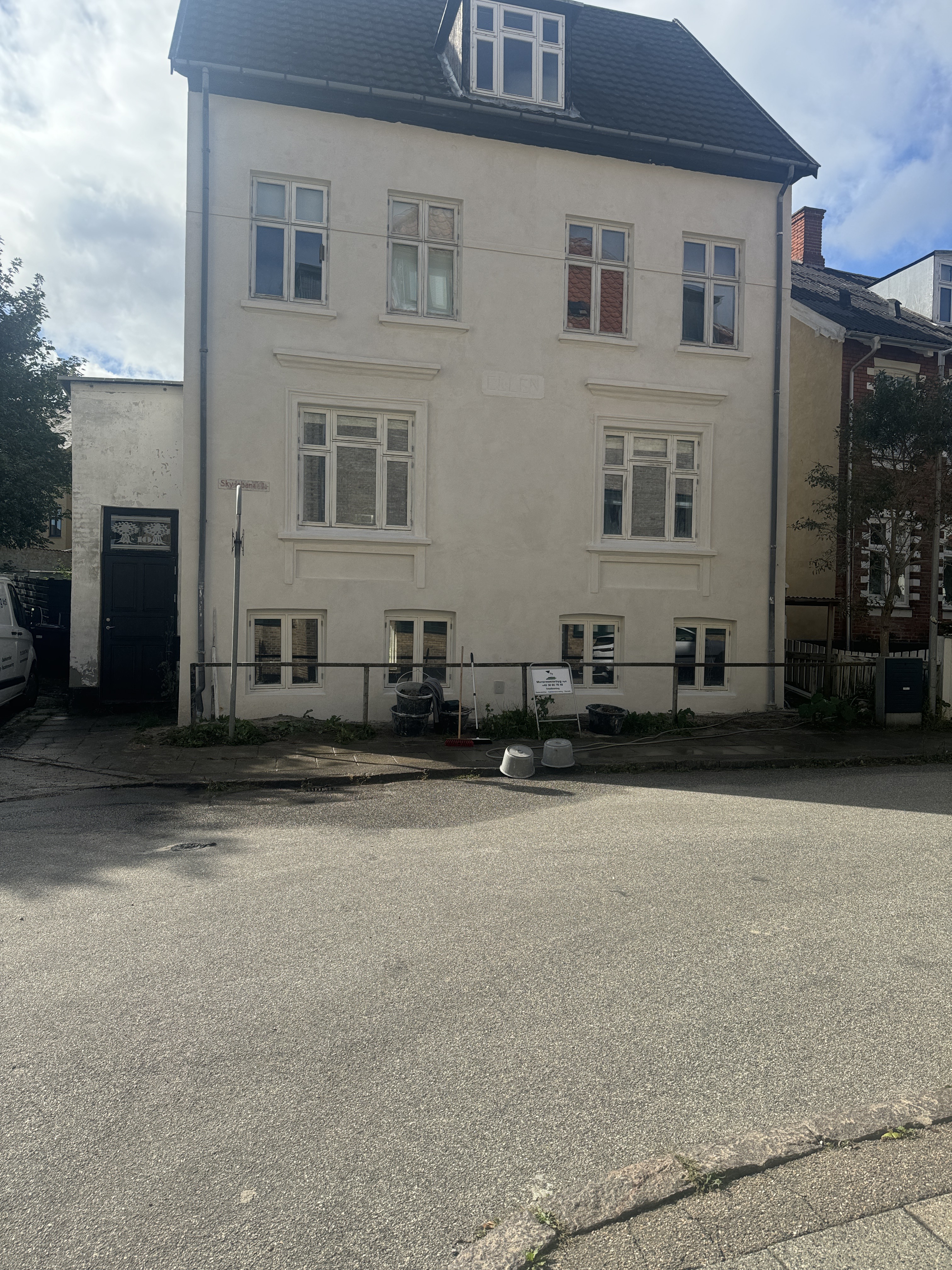 Nyrenoveret facade på byejendom med pudsede og malede vægge